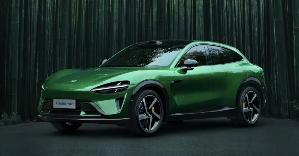 एमरल्ड ग्रीन रंग की नई Xiaomi YU7 Electric SUV एक आधुनिक शहर की सड़क पर खड़ी है।